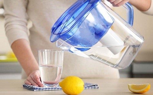 Woman Pouring Water In Glass