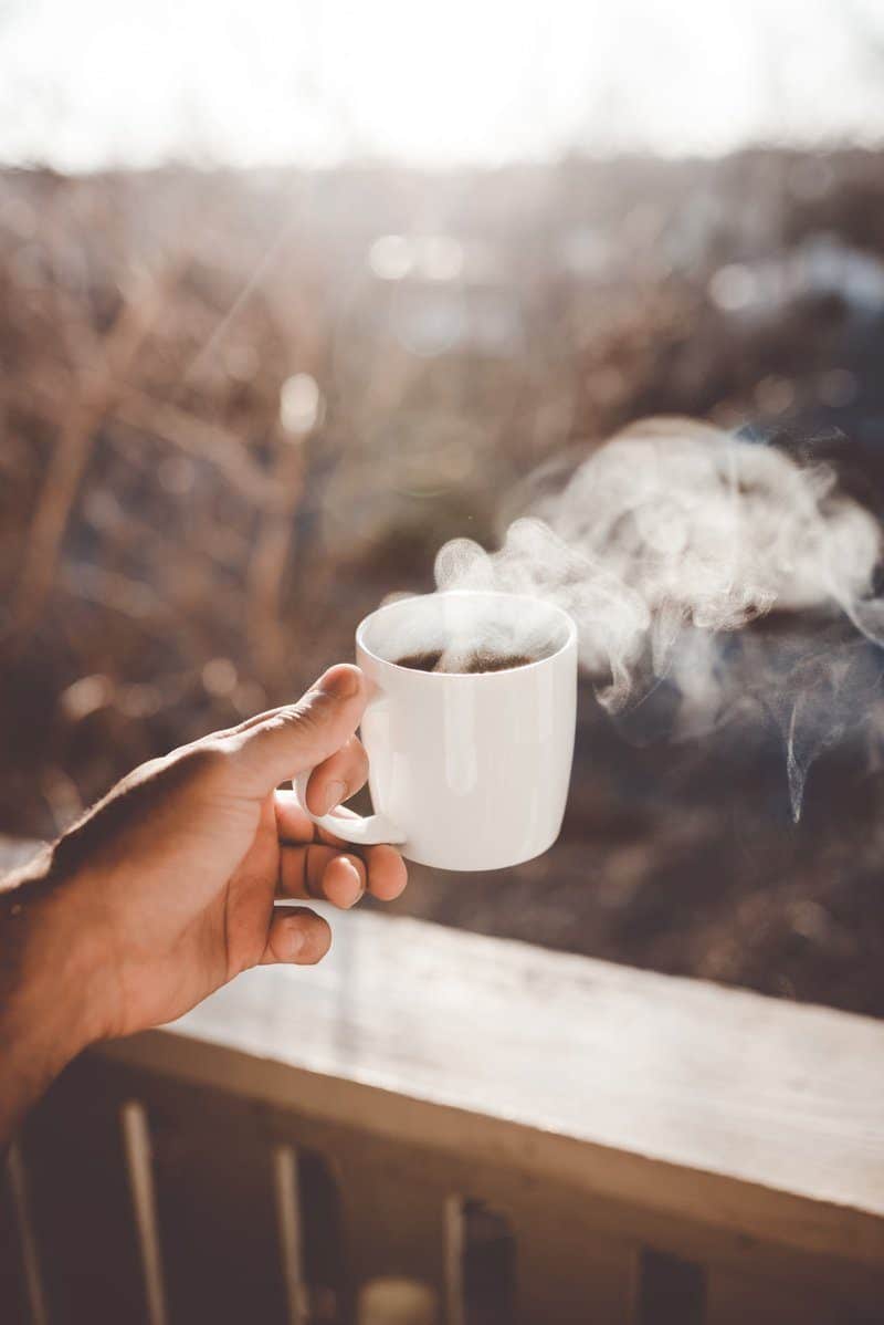 A Person Holding A Cup Of Tea 